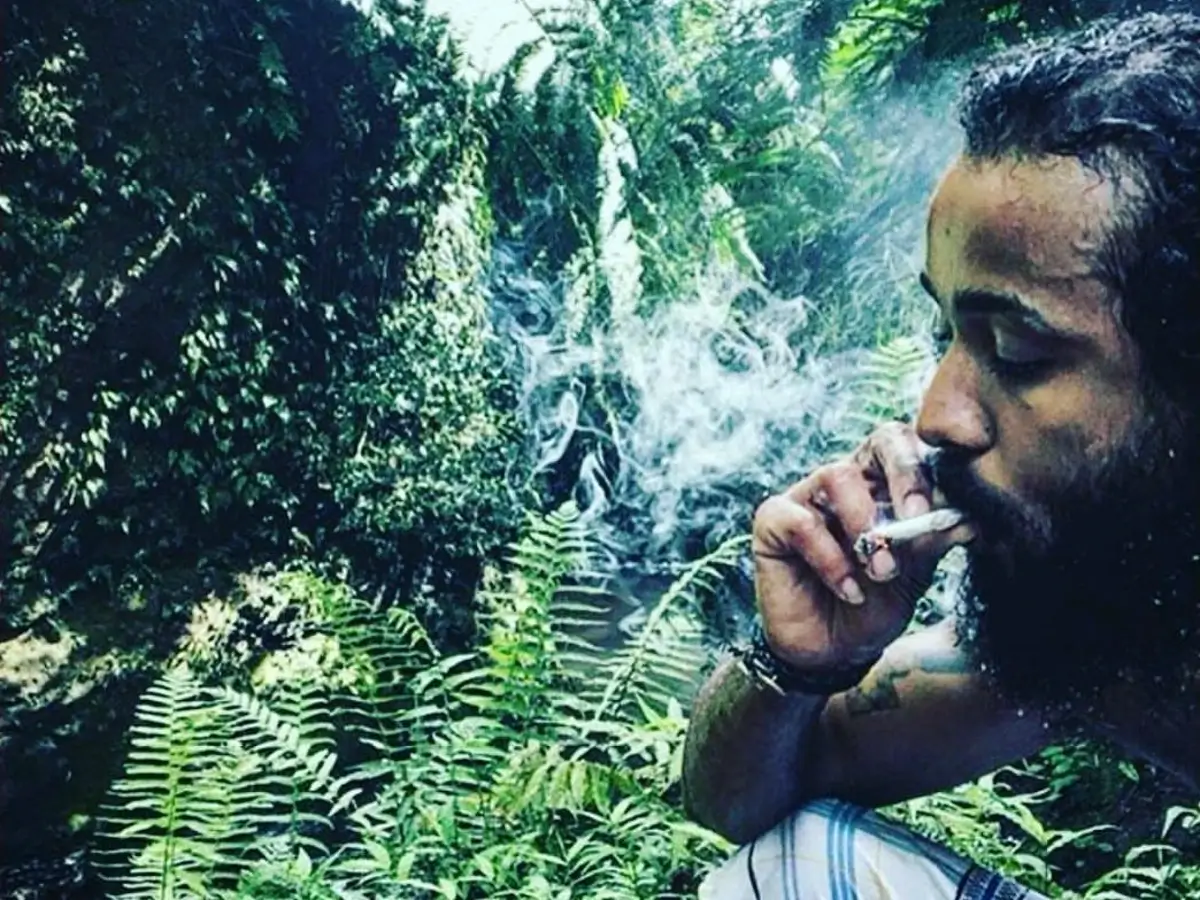 Crven smoking a joint in a rainforest.